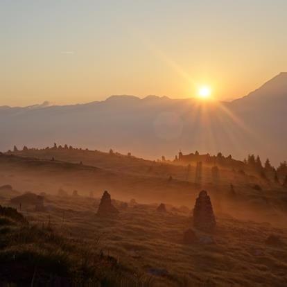 Atmosfera mistica all'alba agli Ometti di pietra sopra Verano in Alto Adige